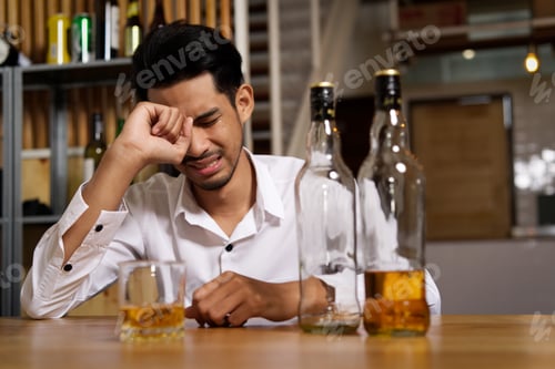 Preview: A man sitting at the pub is crying due to his sadness and want to forget it by drinking alcohol.