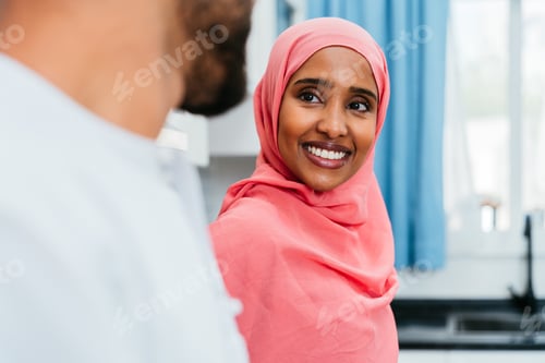 Preview: Happy middle eastern couple wearing traditional arab clothing at home