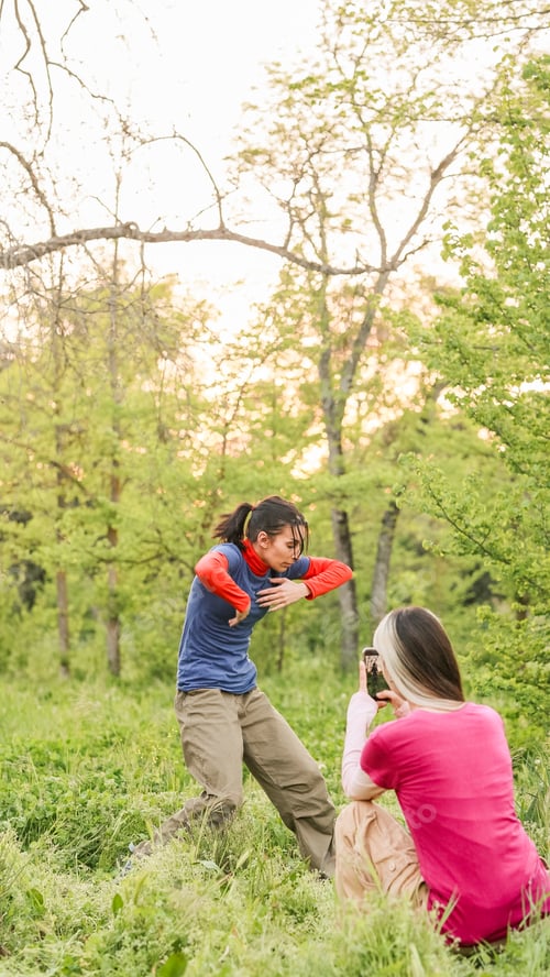 Preview: Woman filming friend dancing outdoors in nature