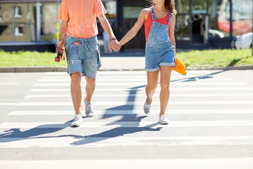 Preview: teenage couple with skateboards on city crosswalk