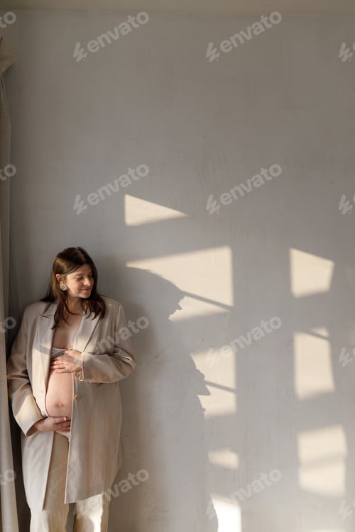 Preview: Pregnant Woman in Blazer Leaning Against Wall