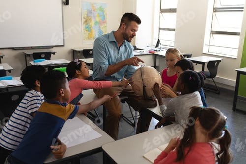 Preview: Male teacher teaching his kids about geography by using globe in classroom