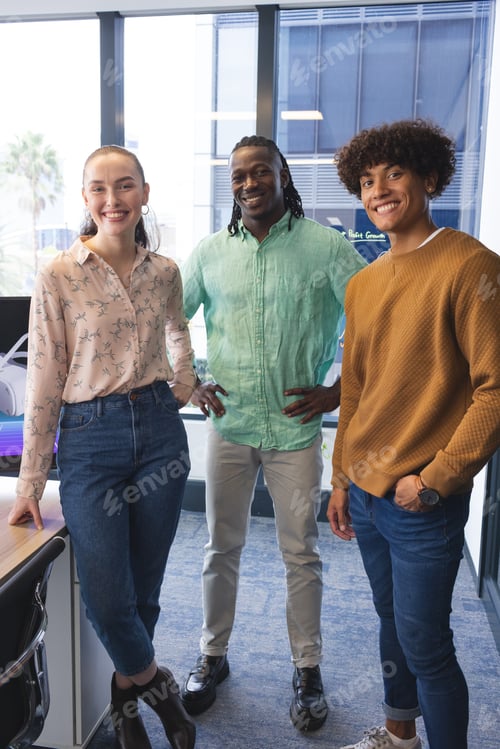 Preview: Diverse group of colleagues standing together, smiling, in a modern business office