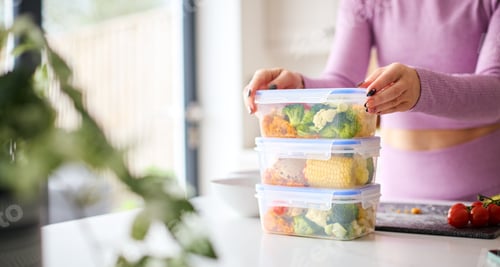Preview: Close Up Of Woman Wearing Fitness Clothing At Home In Kitchen Making Healthy Meals For The Freezer
