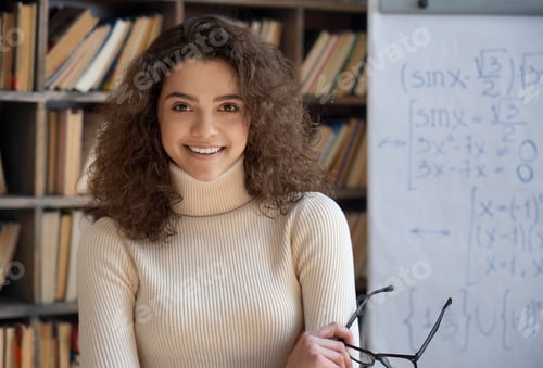 Preview: Confident smiling hispanic woman teacher looking at camera in classroom.