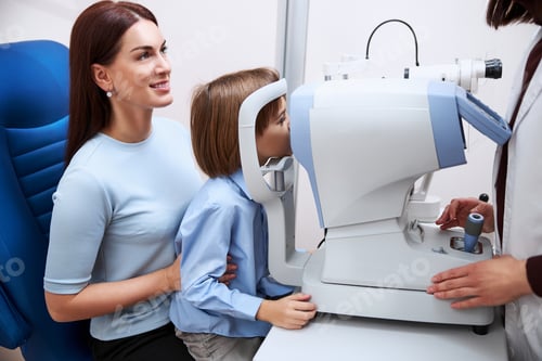 Preview: Physician checking boy eyesight at an autorefractor