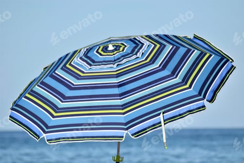 Preview: Striped Beach Umbrella on a Sunny Day at Beach