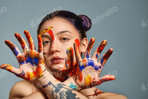 Preview: Portrait of a beautiful girl in the paint. Closeup portrait of a girl with face and hands with