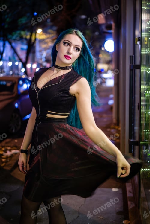 Preview: Young woman stands confidently on the side of the street, wearing a stylish black dress