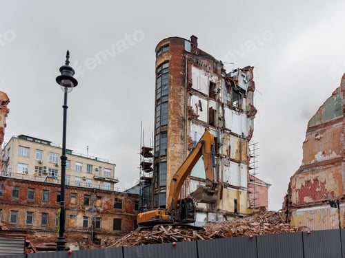 Preview: large building is being demolished by a large excavator.