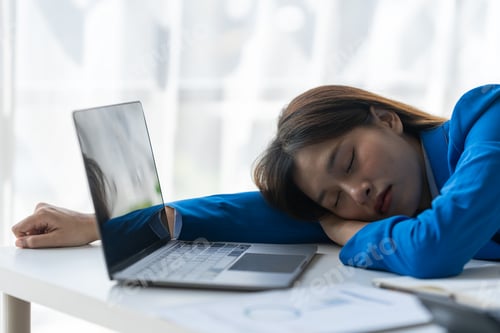Preview: Young frustrated exhausted woman laid her head down on the table sit work at wood desk with laptop i