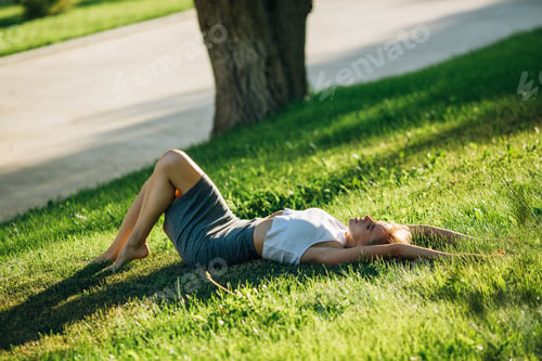 Preview: woman is lying on the grass and looking up to the sky