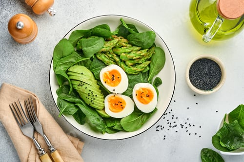 Preview: Fresh vegetable salad with avocado, asparagus, crumpled eggs with black sesame seeds and spinach on