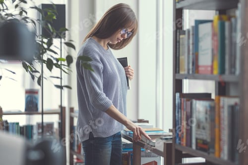 Preview: Woman Browsing Books in a Cozy Library