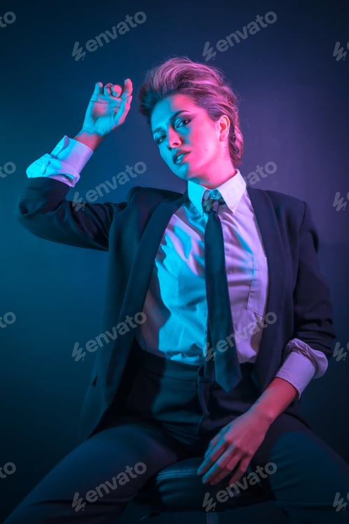 Preview: A sexy young blonde hair female in a black suit posing in studio