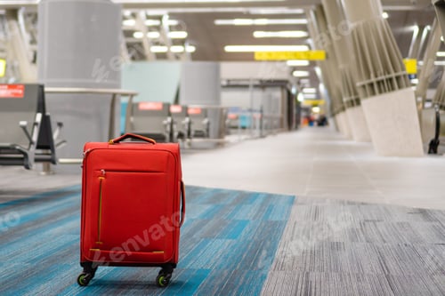 Preview: red wheeled carry-on suitcase, lost at the airport. copy space