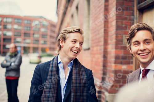 Preview: Happy young male partners standing by building