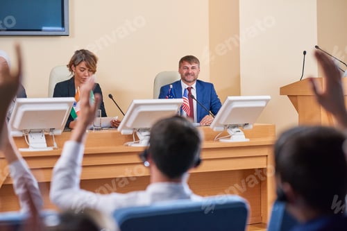 Preview: Happy young delegate in formalwear looking at audience with smile
