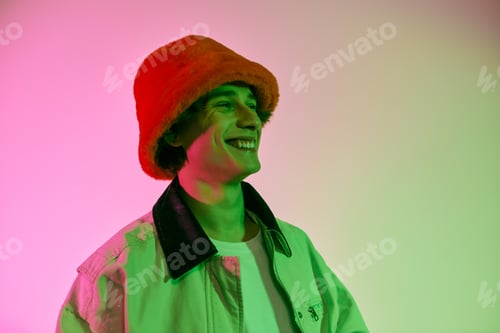 Preview: Stylish young man embraces vibrant colors in a modern studio setting