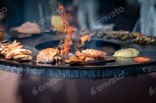 Preview: Different kinds of grilled food near the round barbecue fire