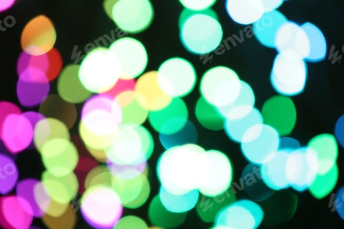 Preview: Blurred view of colorful lights on black background. Bokeh effect