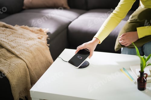 Preview: Charging mobile phone battery with wireless charging device in the table. Smartphone charging