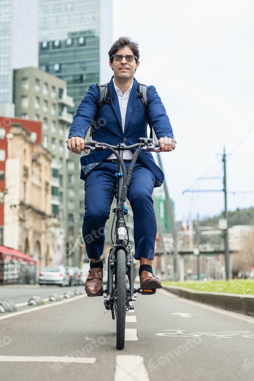 Preview: vertical portrait Businessman Riding Electric Bike on Urban Bike Path with sunglasses and backpack