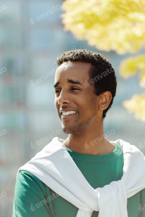 Preview: Happy handsome smiling african american man looking away, outdoors in park