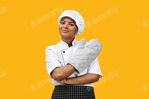 Preview: Confident black female chef with crossed arms wearing an oven mitt