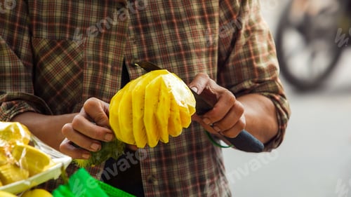 Preview: A Vietnamese street vendor slicing a ripe pineapple with a knife, tropical fruit