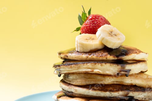 Preview: Pancakes with chocolate and fruit on yellow background