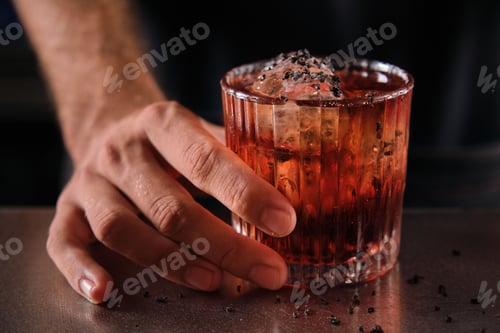 Preview: Anonymous bartender serving Negroni cocktail on counter