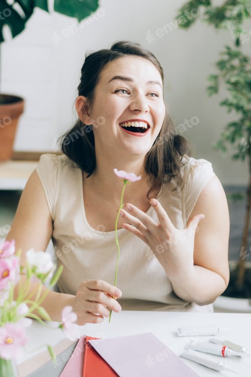 Preview: Portrait of a joyful woman holding a flower