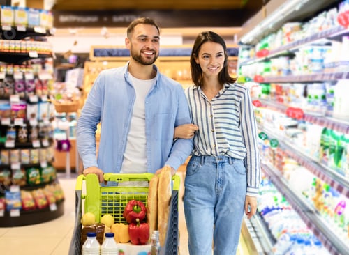 Preview: Cheerful couple with the cart shopping in supermarket