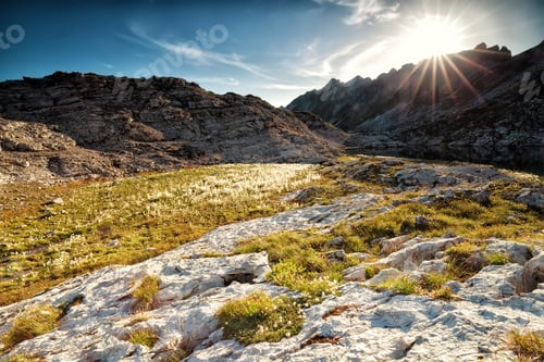 Preview: sunshine over alpinr lake between rocks