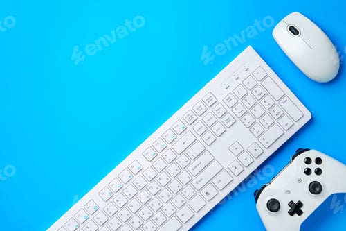 Preview: Computer keyboard and joystick on blue background top view