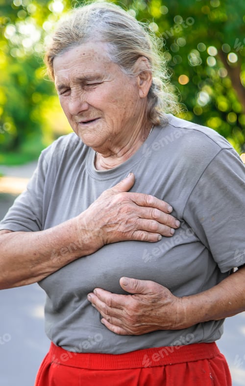 Preview: grandmother hurts heart on the road. Selective focus.