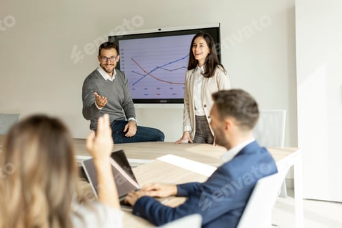 Preview: Young businesspeople presenting project strategy showing ideas on interactive whiteboard in office