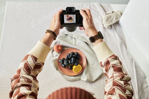 Preview: Man Photographing Fruit Plate with Digital Camera Overhead