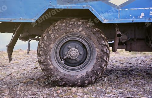 Preview: Wheel closeup in a countryside landscape with a mud road