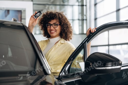 Preview: In the retail shop, near car and with keys. Pretty woman is smiling