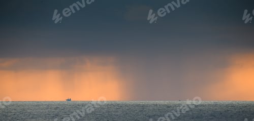 Preview: Rain on the distant horizon in the ocean. Dark clouds and rain poured in the evening.