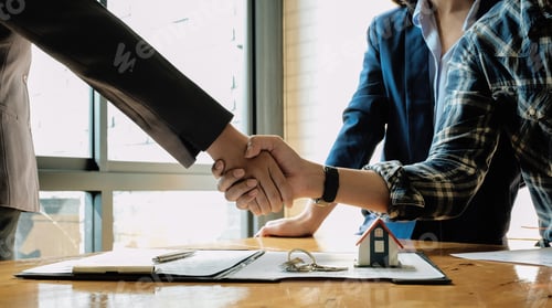 Preview: Real estate agent and customers shaking hands together celebrating finished contract after about