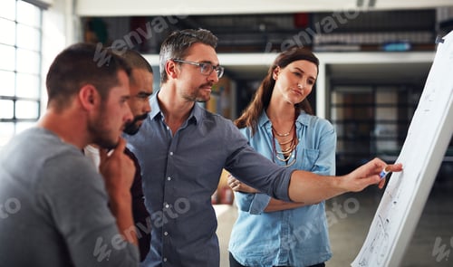 Preview: Shot of a group of colleagues brainstorming together on a whiteboard in an office