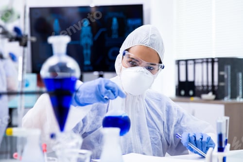 Preview: Researcher mixing a blue liquid in a tube and looking at it