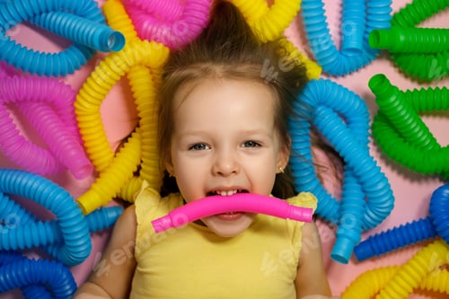 Preview: Girl lies surrounded by a bunch of popular pop tubes toy