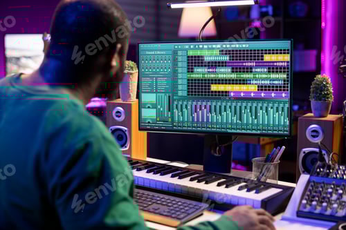 Preview: Man Composing Music at Computer in Urban Workplace