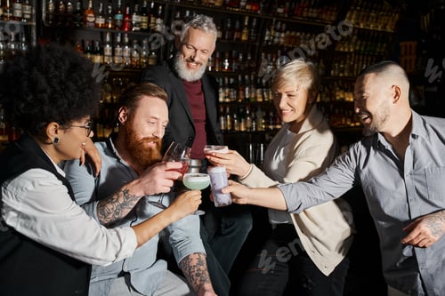Preview: pleased multiethnic work friends clinking glasses during party in bar, leisure and fun after work