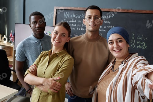 Preview: Selfie of Four English Language Instructors Smiling at Camera in School Classroom
