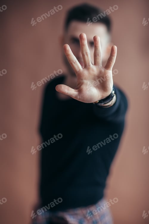 Preview: Portrait of young man doing stop symbol